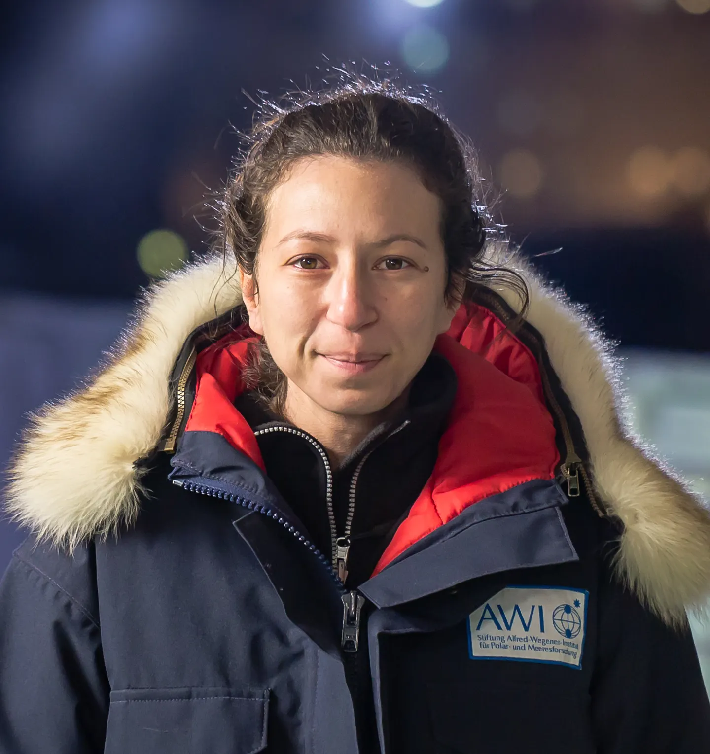 Photo portrait of Amy with shoulder length brown hair, wearing a winter coat and a smile.
