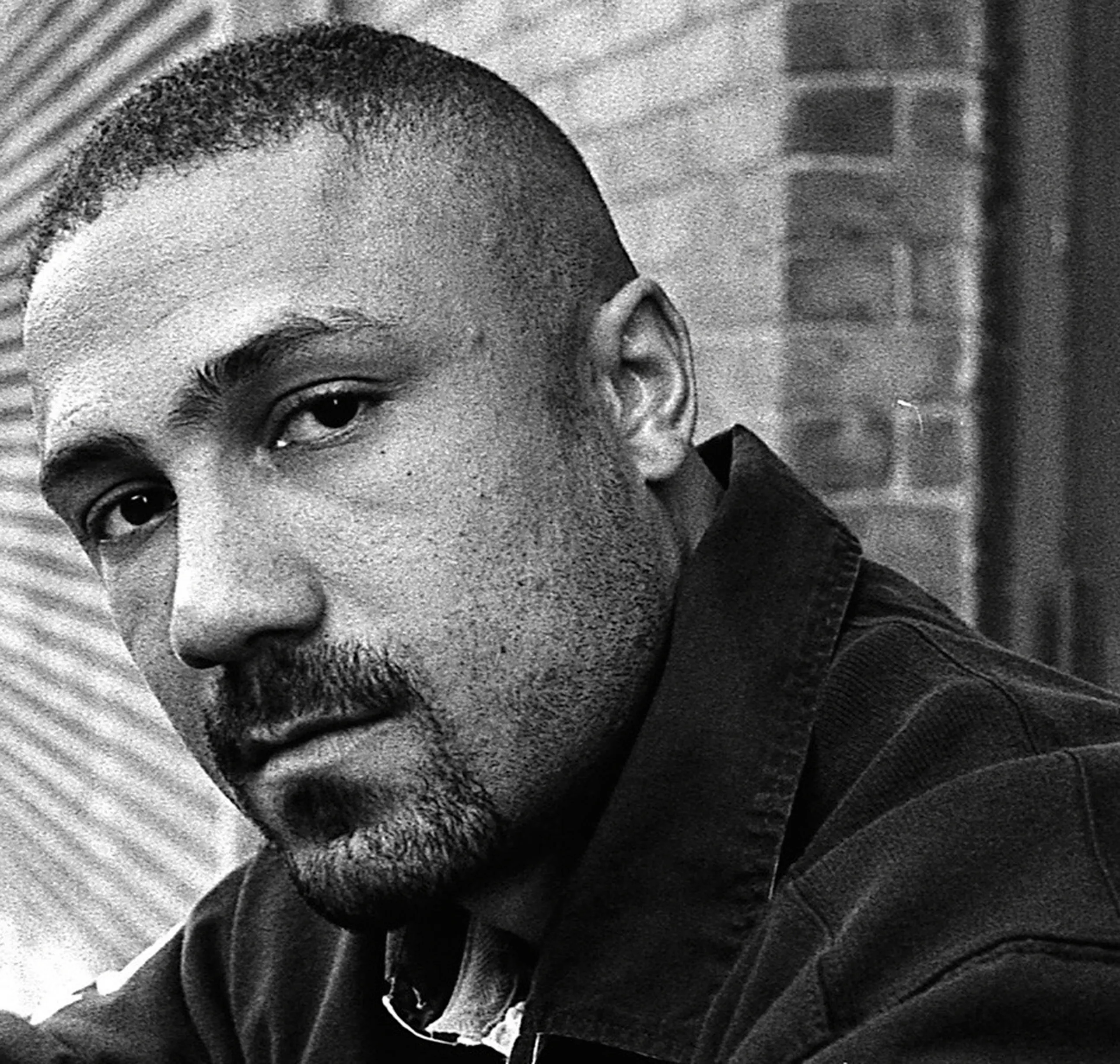 Photo portrait of Khalik in black and white with short dark hair and a goatee.
