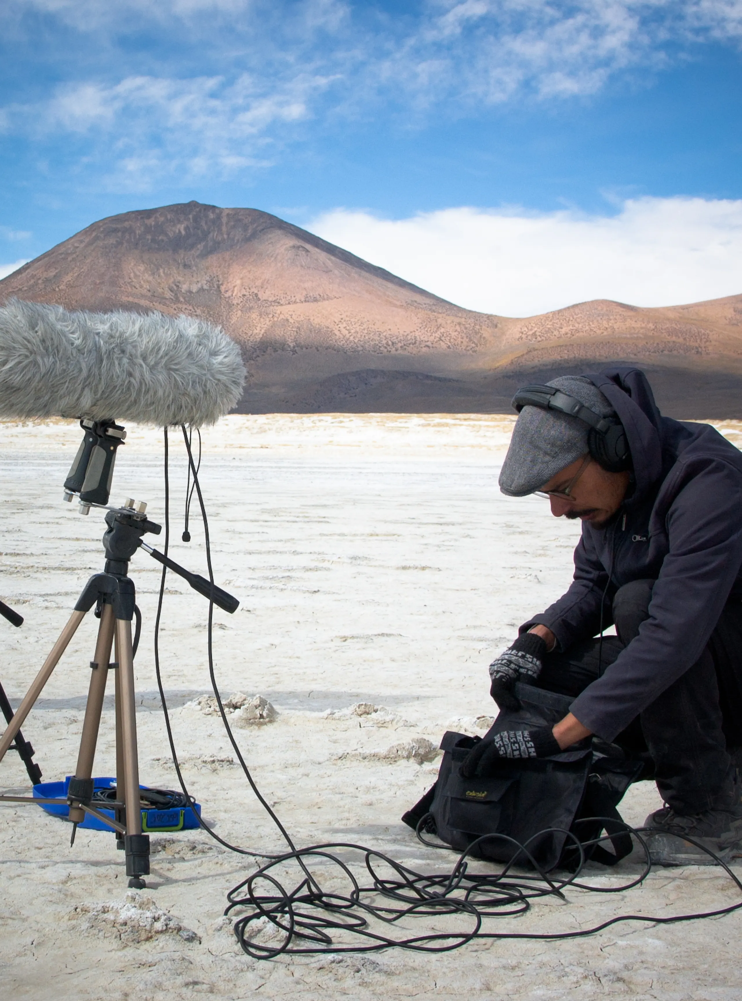 Photo of a man (Fernando) in the desert with a large furry microphone.